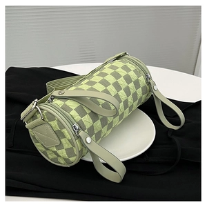 Close-up of light green checkerboard cylinder bag with textured pleats and silver zipper