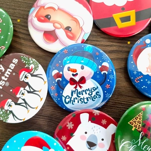 Detailed view of colorful Christmas tinplate badges with Santa, snowman and tree designs
