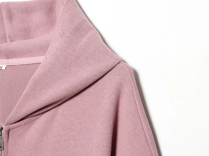 Gros plan d'un sweat à capuche rose avec texture en maille et étiquette de taille S