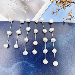 Macro detail of natural freshwater pearls on a long gold plated tassel earring drop