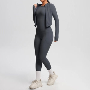 Three-piece dark grey yoga set with zip-up jacket and pocket leggings on model