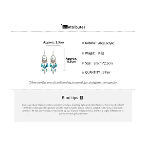 Detail view of ethnic crescent earrings with blue beads and leaf pendants