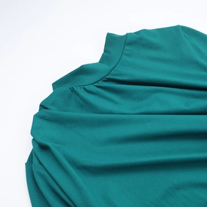 Gros plan sur les coutures du col montant de la robe longue vert foncé à manches