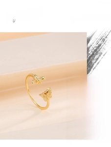 Detailed close-up of open adjustable gold ring with delicate bee and butterfly charms