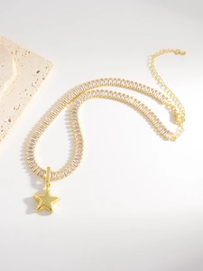 Detailed macro view of gold-plated star pendant necklace with rectangle cut zircons