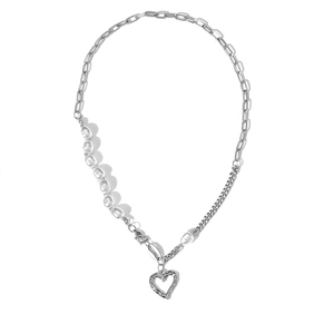 Detail of multi-layered pearl necklace with silver heart pendant and paperclip chain