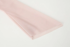 Close-up of pink mesh fabric on shoulder top showing delicate ruffled texture