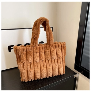 Detailed view of the brown plush tote bag featuring elegant vertical pleated textures