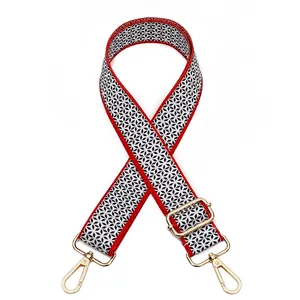 Close-up of adjustable fabric bag strap with red edges and black-white star patterns