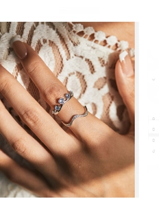 Close-up of S925 sterling silver wave ring with pavé diamonds and light blue gemstones