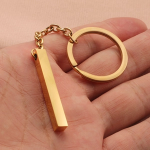 Gold stainless steel bar keychain with mirror finish and ring link on pink fabric