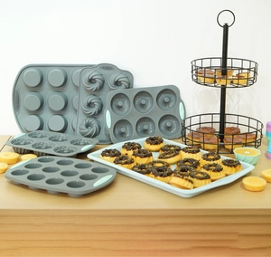Various silicone baking pans with non-stick surface and metal cooling rack on wood table