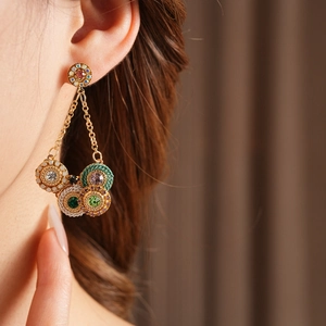 Boucles d'oreilles vintage dorées avec pierres colorées et franges sur mannequin