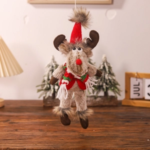 Close-up of a plush Christmas reindeer ornament with a red knit hat and festive scarf