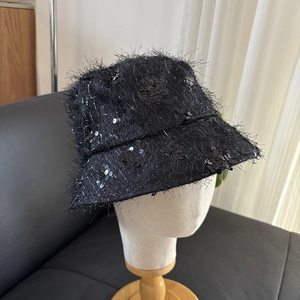 Détail d'un chapeau bob noir avec des paillettes brillantes et une texture frangée