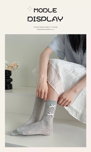 Detail of grey knitted bow socks featuring vertical ribbed texture and mesh design
