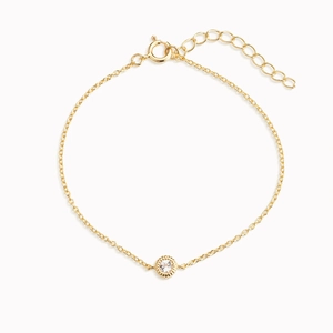 Detail of thin gold S925 sterling silver bracelet featuring a round sparkling zircon stone