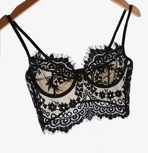 Detail of black eyelash lace embroidery on a backless thin bralette on a hanger