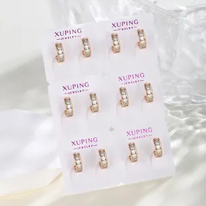Detail of six pairs of gold-plated hoop earrings with square zircon on display card