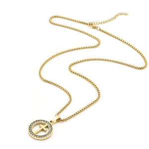 Detailed close-up of a gold box chain necklace with a zircon-encrusted cross pendant