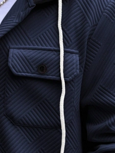 Macro detail of navy geometric quilted fabric with flap pocket and white drawstring
