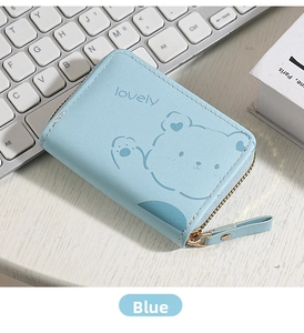 Close-up of blue zippered coin purse with cartoon bear print on a white desk