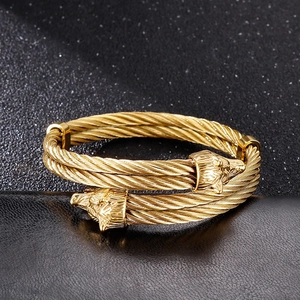 Golden double wolf head stainless steel cable bangle with a vintage twisted wire design