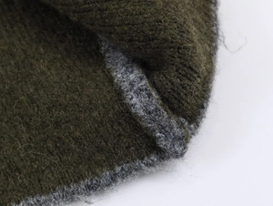 Detailed close-up of double-sided olive green and grey knitted mohair fabric texture