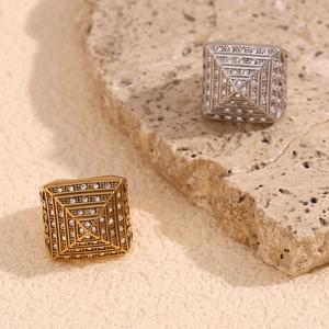 18K gold and silver pyramid rings with zircon pavé setting on textured stone background