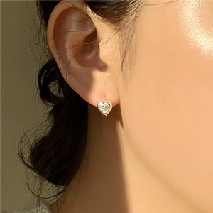Elegant 925 sterling silver heart stud earrings with clear zircon on model's ear