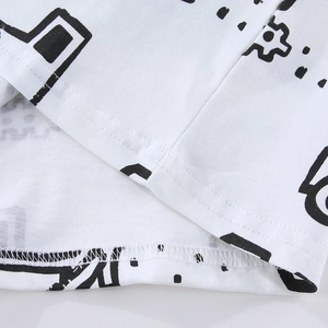 Close-up of boys' white T-shirt with black pixel prints and durable double-stitched hem.