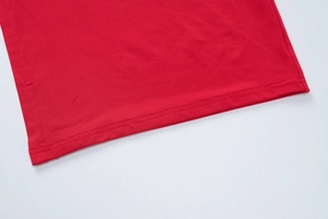Détail de la robe d'été rouge montrant l'ourlet à double couture et le tissu en maille élastique