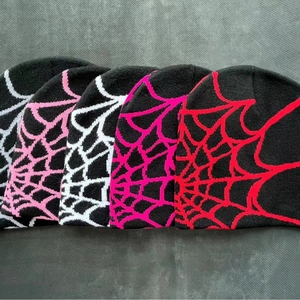 Five-pack of knitted beanies with spider web jacquard patterns in multiple colors