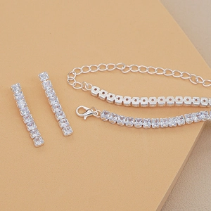 Detailed macro view of square zircon tennis bracelet and dangling bar earrings set
