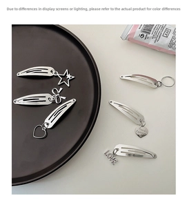 Detailed view of silver metal hair clips with star, heart and butterfly charm pendants