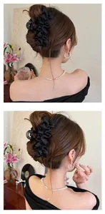 Détail d'une grande pince à cheveux en satin plissé noir portée par un mannequin de dos