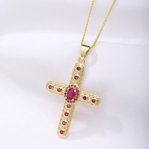 Detailed macro shot of golden cross pendant with rose zircon on white silk background