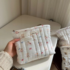 Close-up of quilted cotton makeup bag with cute animal patterns and simple wish label
