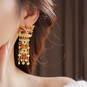 Dettaglio orecchini vintage a forma di leone con placcatura oro e perle eleganti