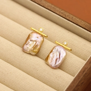 Baroque pearl earrings with gold plating and sparkling crystals in a wooden jewelry box