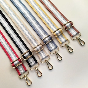 Close-up of colorful adjustable striped bag straps with metallic yarn and gold hooks