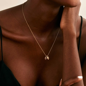 Golden necklace with marquise-cut marquise birthstone pendant on a dark-skinned model
