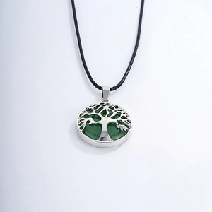 Detail of silver tree of life pendant with green natural stone and black cord necklace