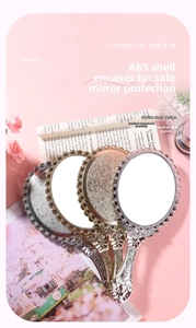 Detailed close-up of retro embossed floral pattern on silver handheld makeup mirror