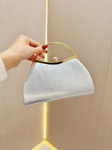 Elegant silver evening clutch bag with a gold metal handle and sparkling rhinestone clasp