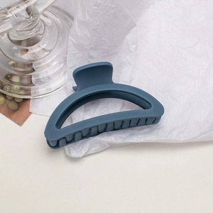 Macro shot of large matte misty blue hair claw clip with minimalist cutout design