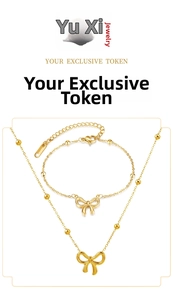 Close-up of golden bow-shaped jewelry set featuring bead chain necklace and bracelet