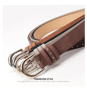 Detail of suede leather belts with silver U-shaped buckles and micro rivet accents