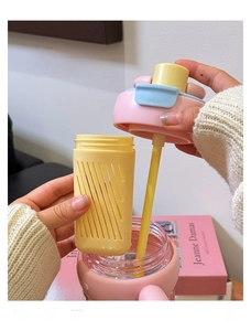 Detailopname van de roze en gele waterfles met verwijderbare theefilter en infuser