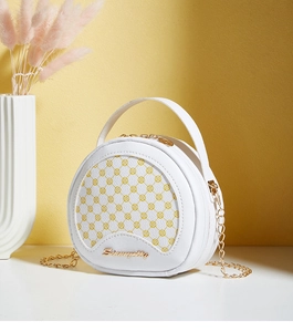 Détail du sac circulaire blanc en cuir PU avec motif losanges jaunes et chaîne dorée